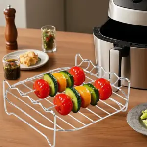 Silberner Etagenrost mit Gemüsespießen auf einem Holztisch neben einem Airfryer