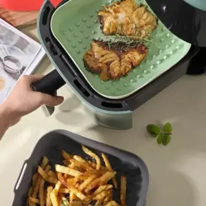 Grüne Silikon-Einlage mit Fischstücken in der Heißluftfritteuse