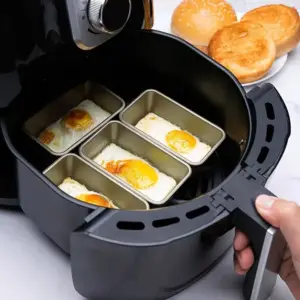 Silberne Backformen mit Spiegeleiern im Airfryer-Korb