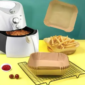 Quadratische Einlage mit gewelltem Rand auf einem Gitter neben einem weißen Airfryer