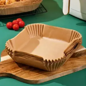 Stapel eckiger brauner Papier-Einlagen auf einem Holzbrett neben Tomaten