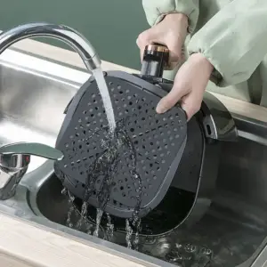 Graue gelochte Silikonmatte für die Heißluftfritteuse, unter fließendem Wasser abgespült