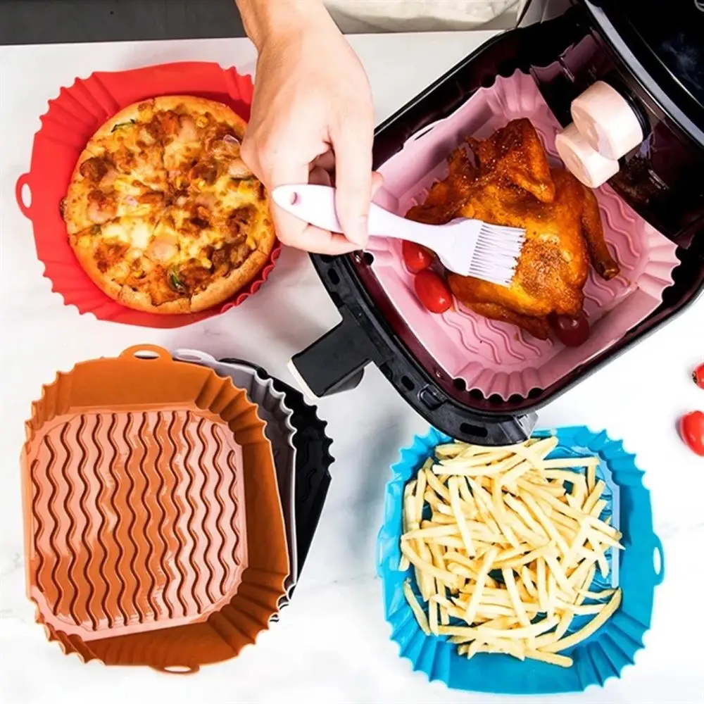 Mehrere eckige Silikoneinlagen in verschiedenen Farben mit Pizza und Hähnchen